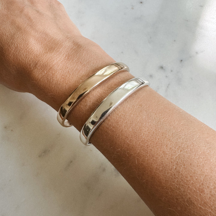 Person Wears the MIMOSA Handcrafted Thin Dome Bracelets in Sterling Silver and Bronze