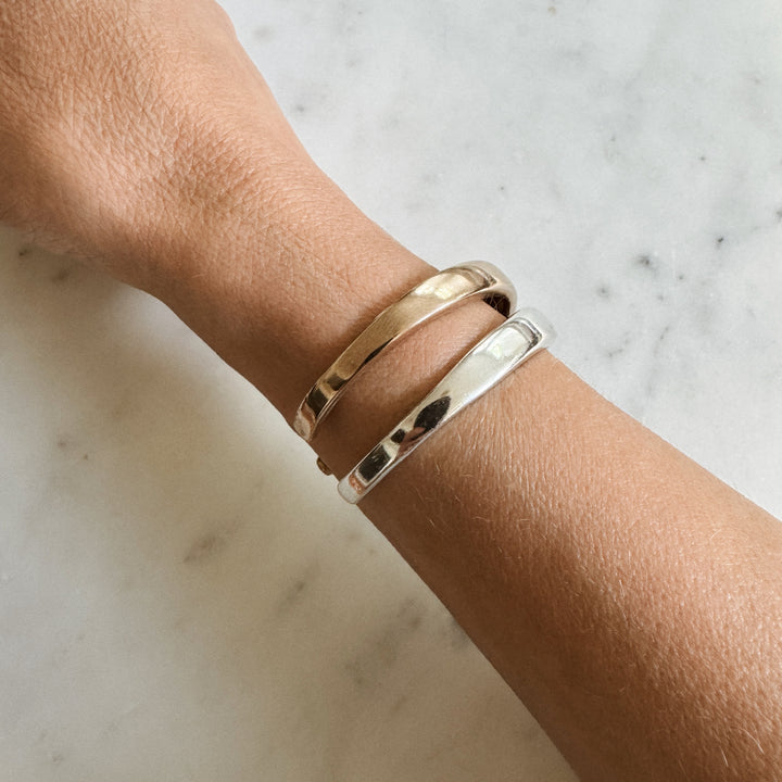 Person Wears the MIMOSA Handcrafted Thin Dome Bracelets in Sterling Silver and Bronze