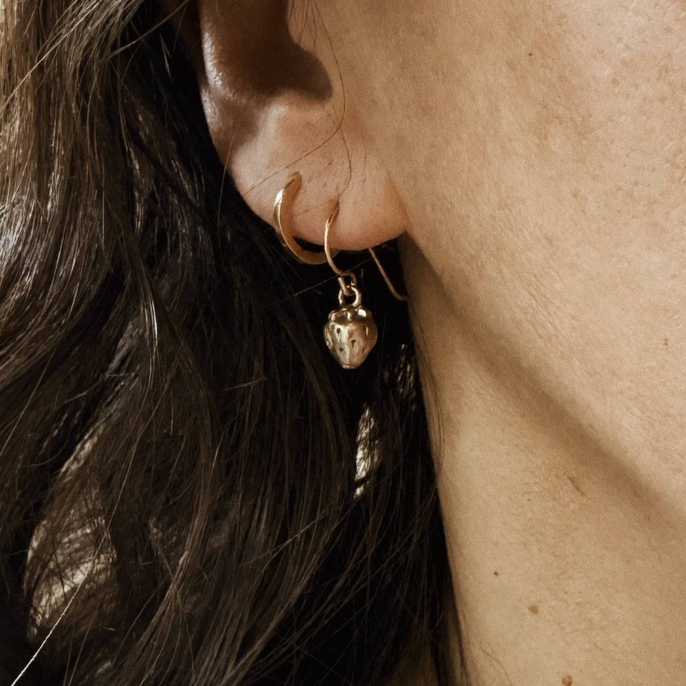 Woman Wears the MIMOSA Handcrafted Strawberry Earrings in Bronze