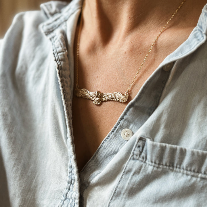 Woman Wears the MIMOSA Handcrafted Owl Necklace in Bronze