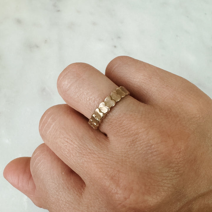 Woman Wears the MIMOSA Handcrafted Heart to Heart Ring in Bronze