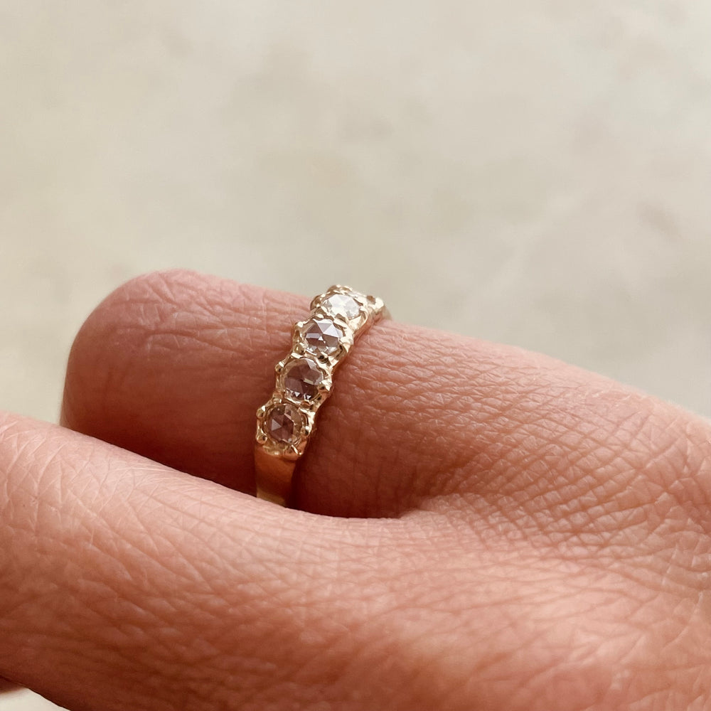 Five 3-millimeter rose cut diamonds set in a simple and delicate 14k gold ring