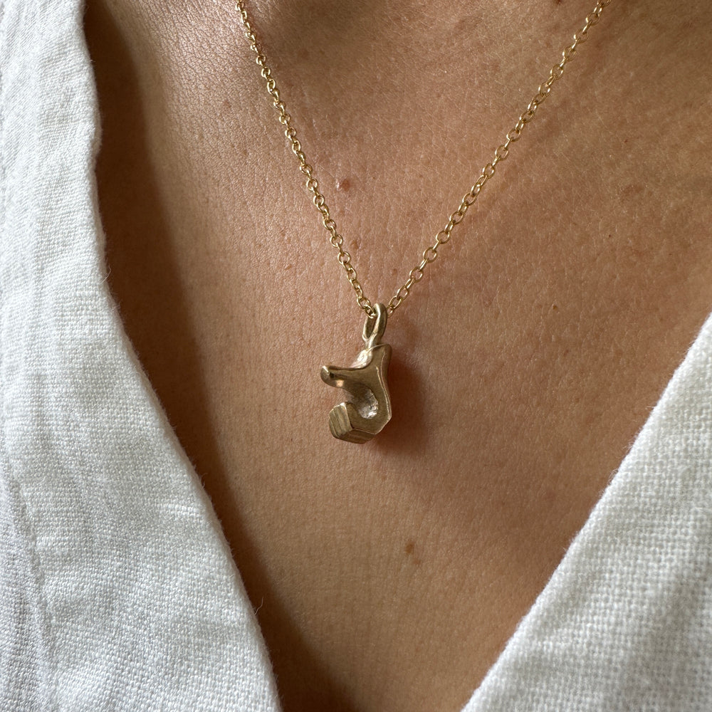 Woman Wears MIMOSA Handcrafted Heart Hand Necklace in Bronze