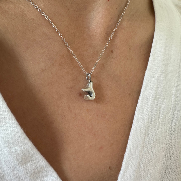 Woman Wears MIMOSA Handcrafted Heart Hand Necklace in Sterling Silver
