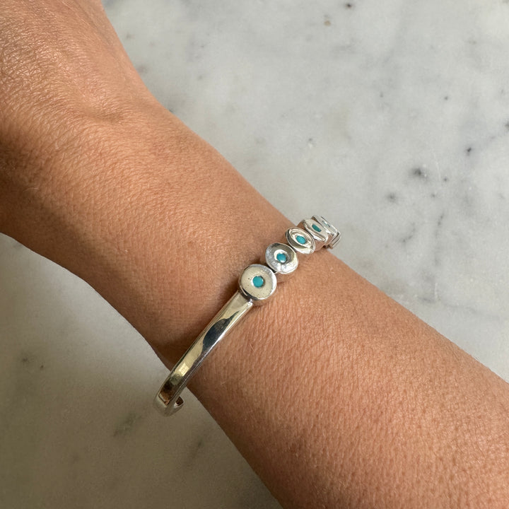 Woman Wears the MIMOSA Handcrafted Minimal Circle Stone Cuff with Turquoise in Sterling Silver. 
