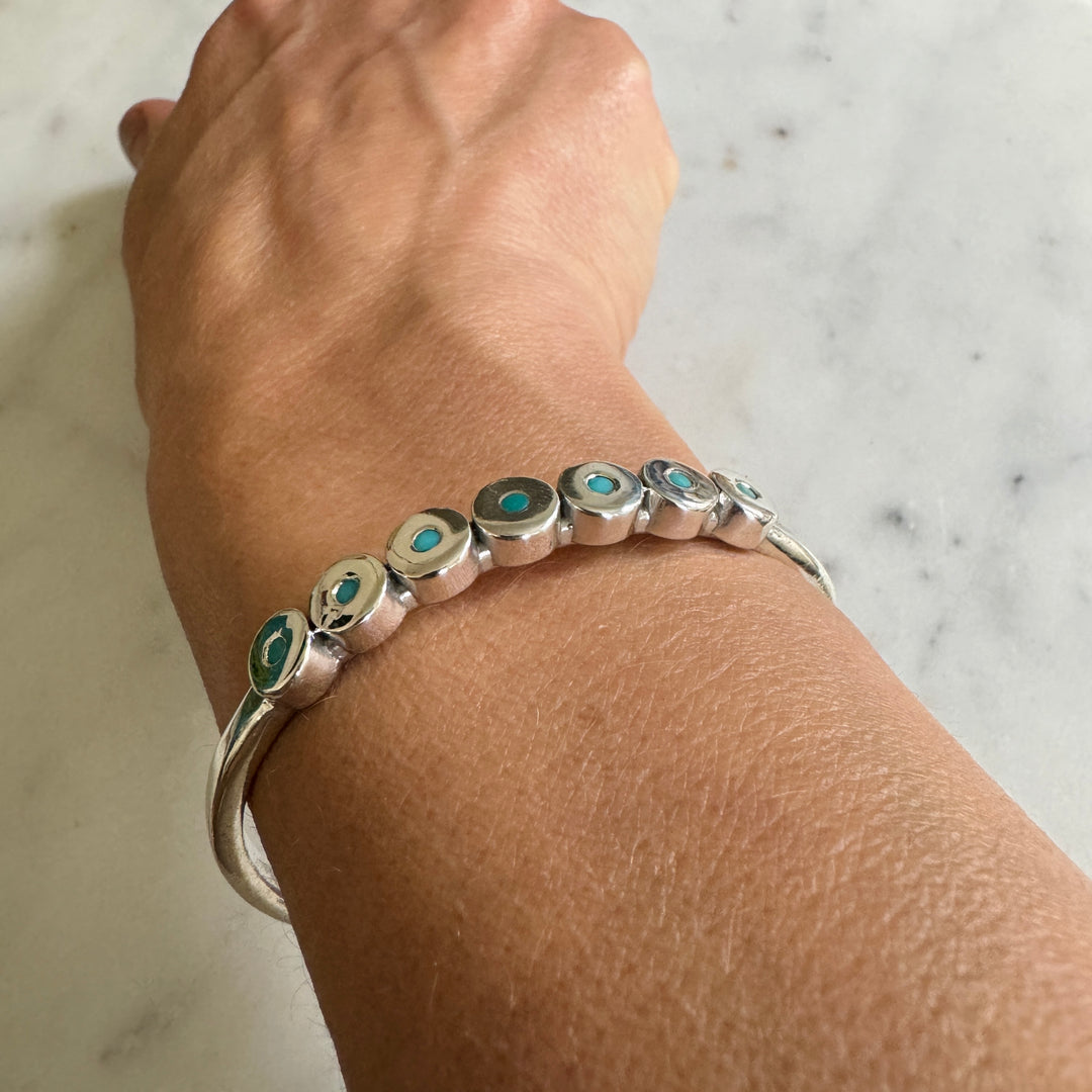 Woman Wears the MIMOSA Handcrafted Minimal Circle Stone Cuff with Turquoise in Sterling Silver. 