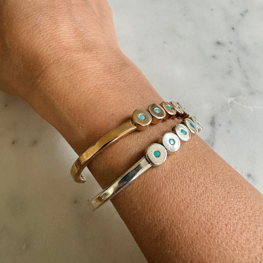 Woman Wears the MIMOSA Handcrafted Minimal Circle Stone Cuff with Turquoise in Bronze and Sterling Silver. 