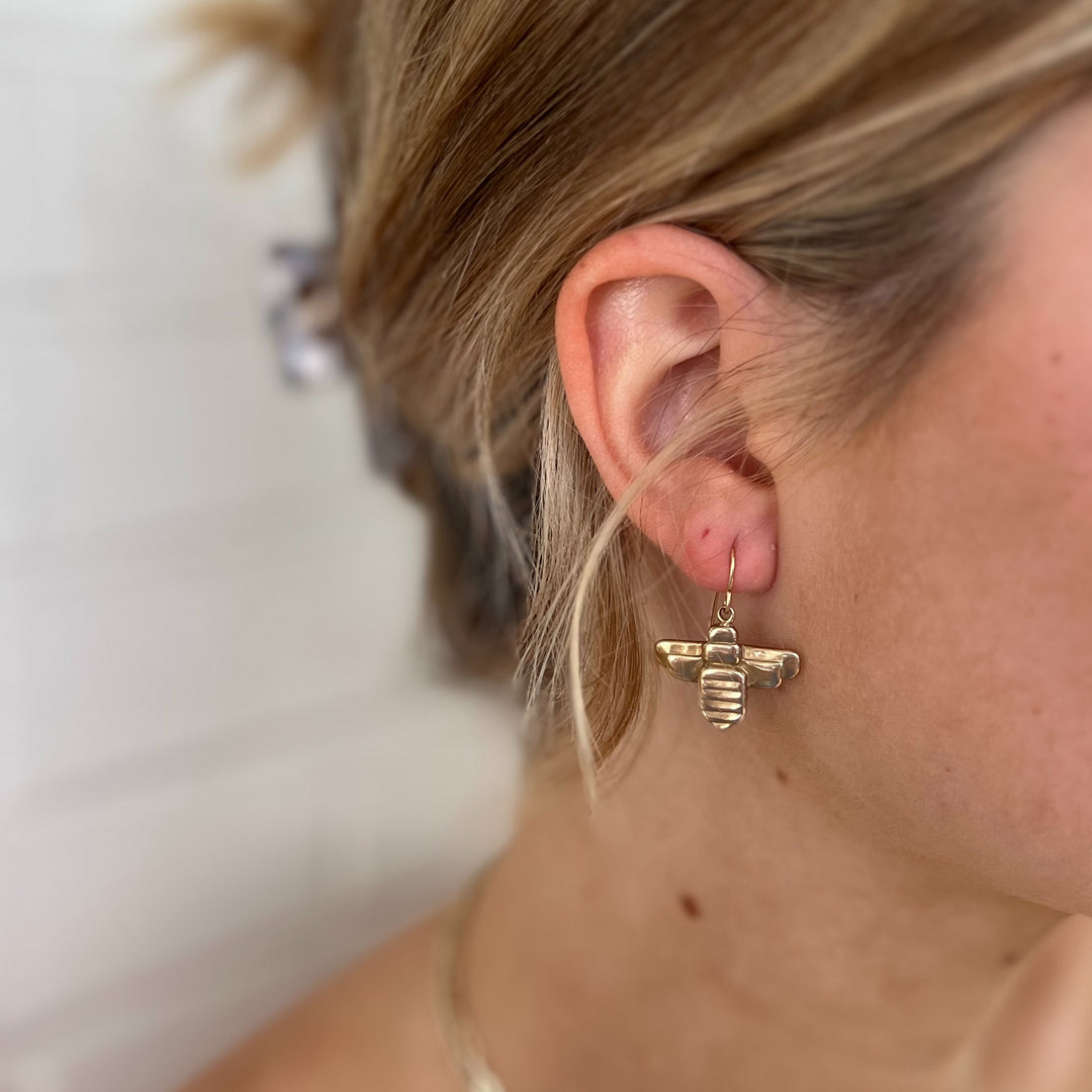 Woman Wears MIMOSA Handcrafted Bee Earrings in Bronze.