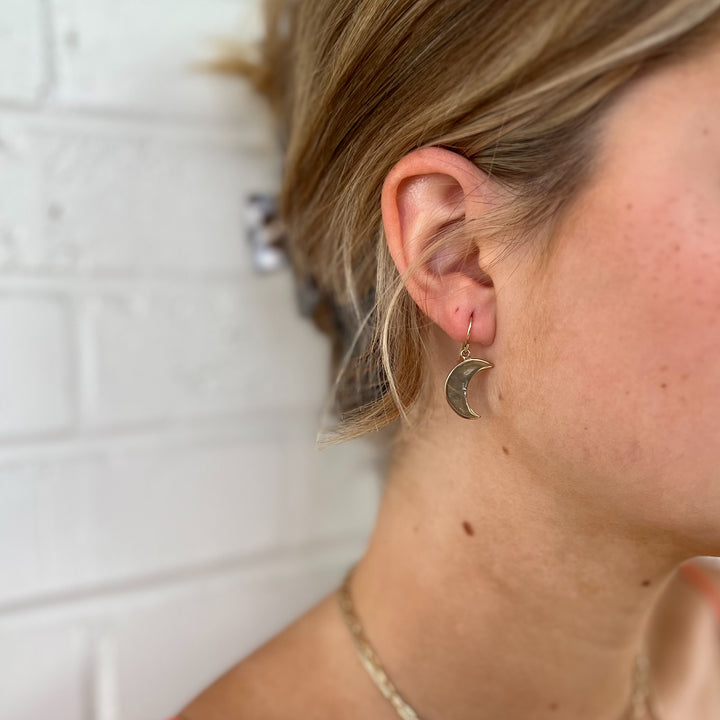 Woman Wears MIMOSA Handcrafted Crescent Moon Earrings in Bronze.