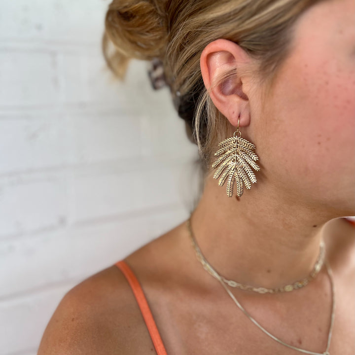 Woman Wears MIMOSA Handcrafted Large Mimosa Leaf Earrings in Bronze.