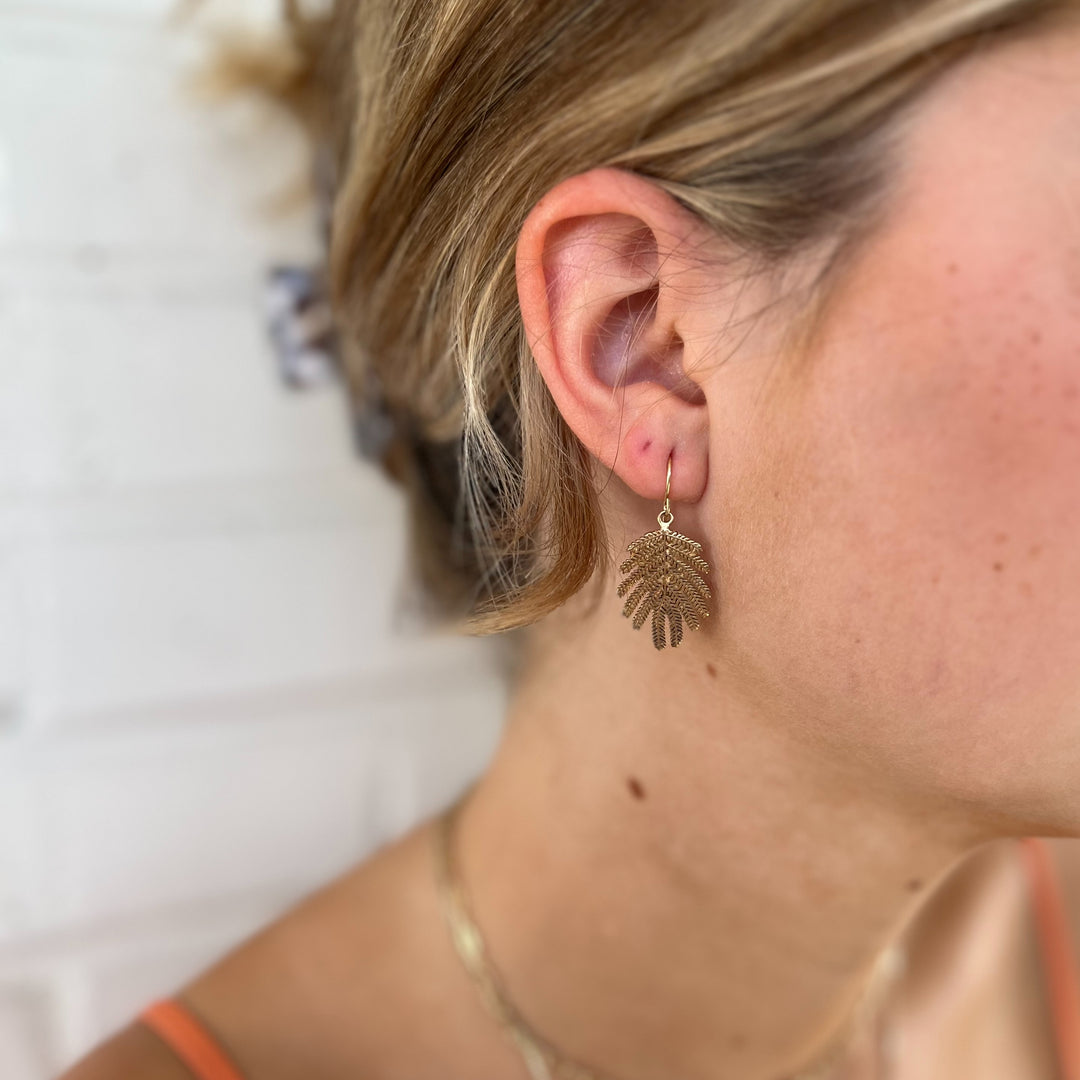 Woman Wears MIMOSA Handcrafted Small Mimosa Leaf Earrings in Bronze.
