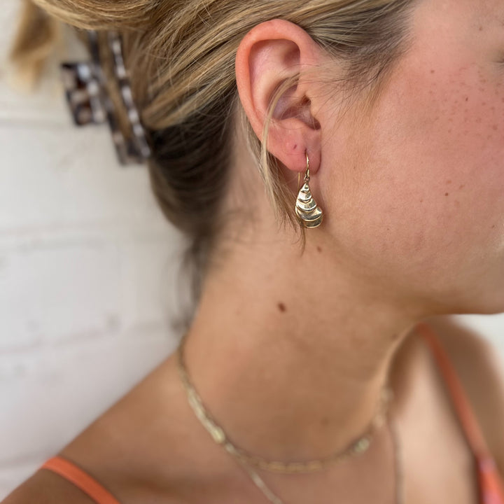 Woman Wears MIMOSA Handcrafted Oyster Earrings in Bronze.