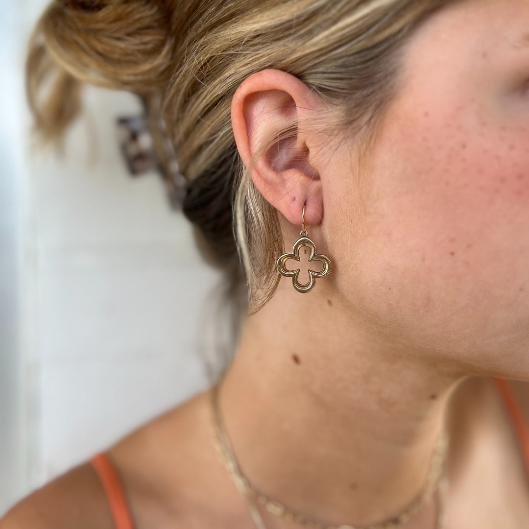 Woman Wears MIMOSA Handcrafted Quatrefoil Earrings in Bronze.