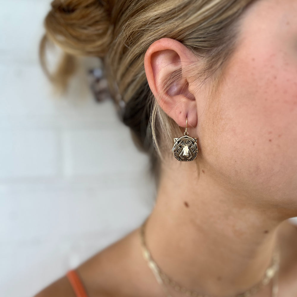 Woman Wears MIMOSA Handcrafted Tiger Earrings in Bronze.