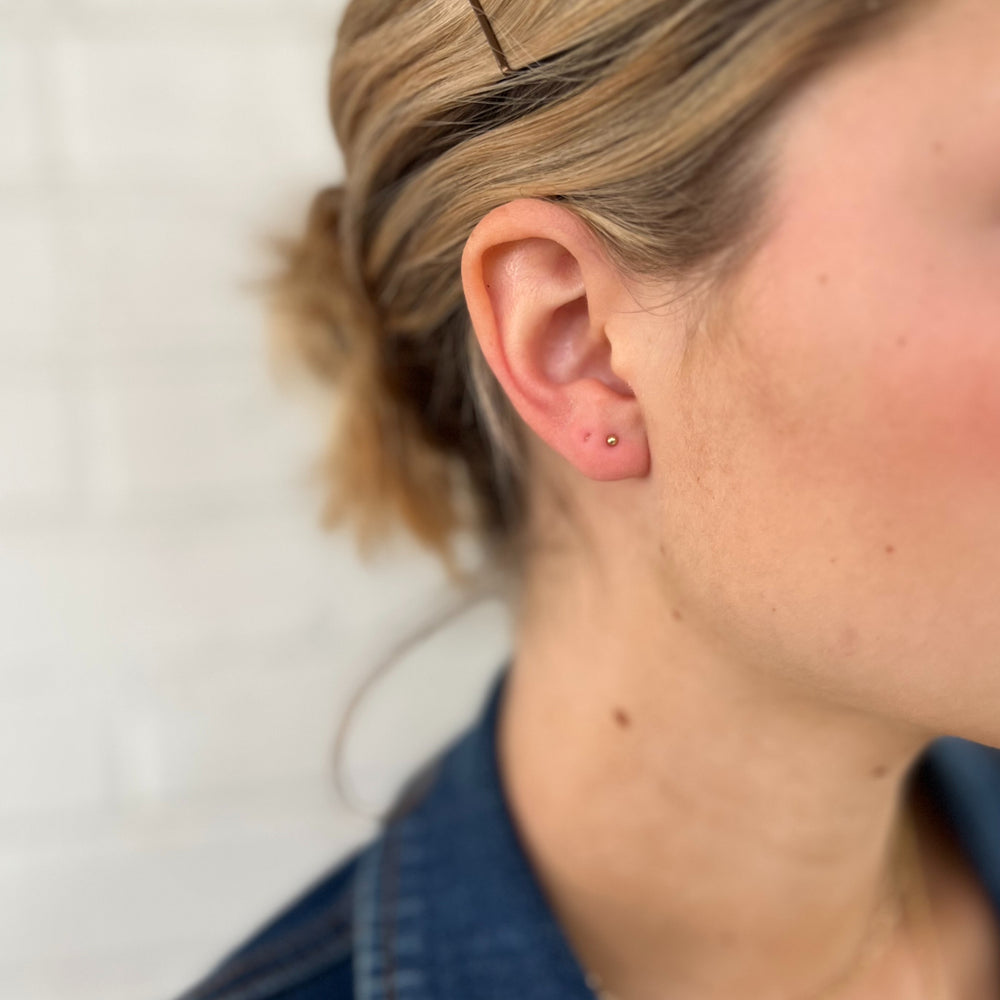 Woman Wears the MIMOSA Handcrafted Gold-Filled Tiny Studs.