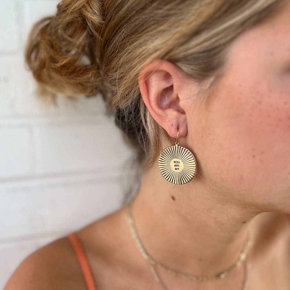 Woman Wears MIMOSA Handcrafted Large You Are My Sunshine Earrings in Bronze.
