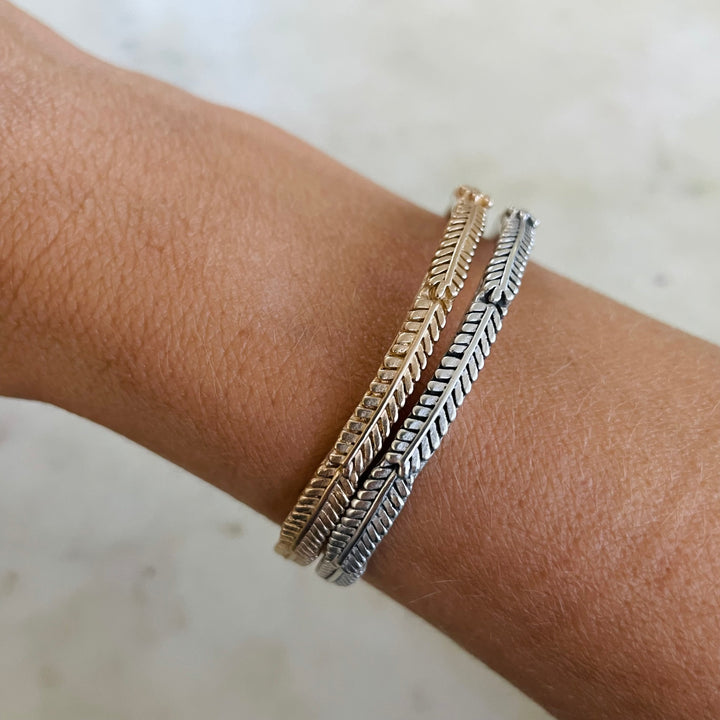 Woman Wearing Handmade Bronze and Silver Mimosa Sprig Cuff Bracelets