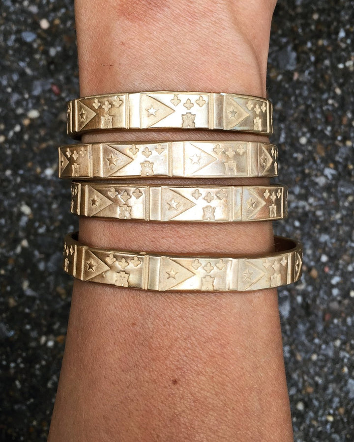 Woman Wearing a stack of 4 Bronze Acadian Flag Bracelets