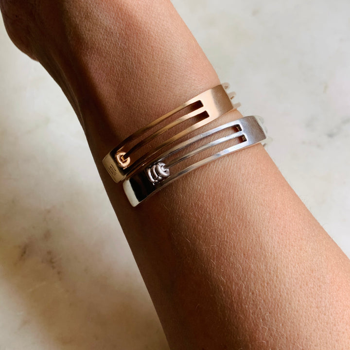 Woman Wearing Handmade Bronze and Sterling Silver Daydreamer Cuff Bracelets with moving parts