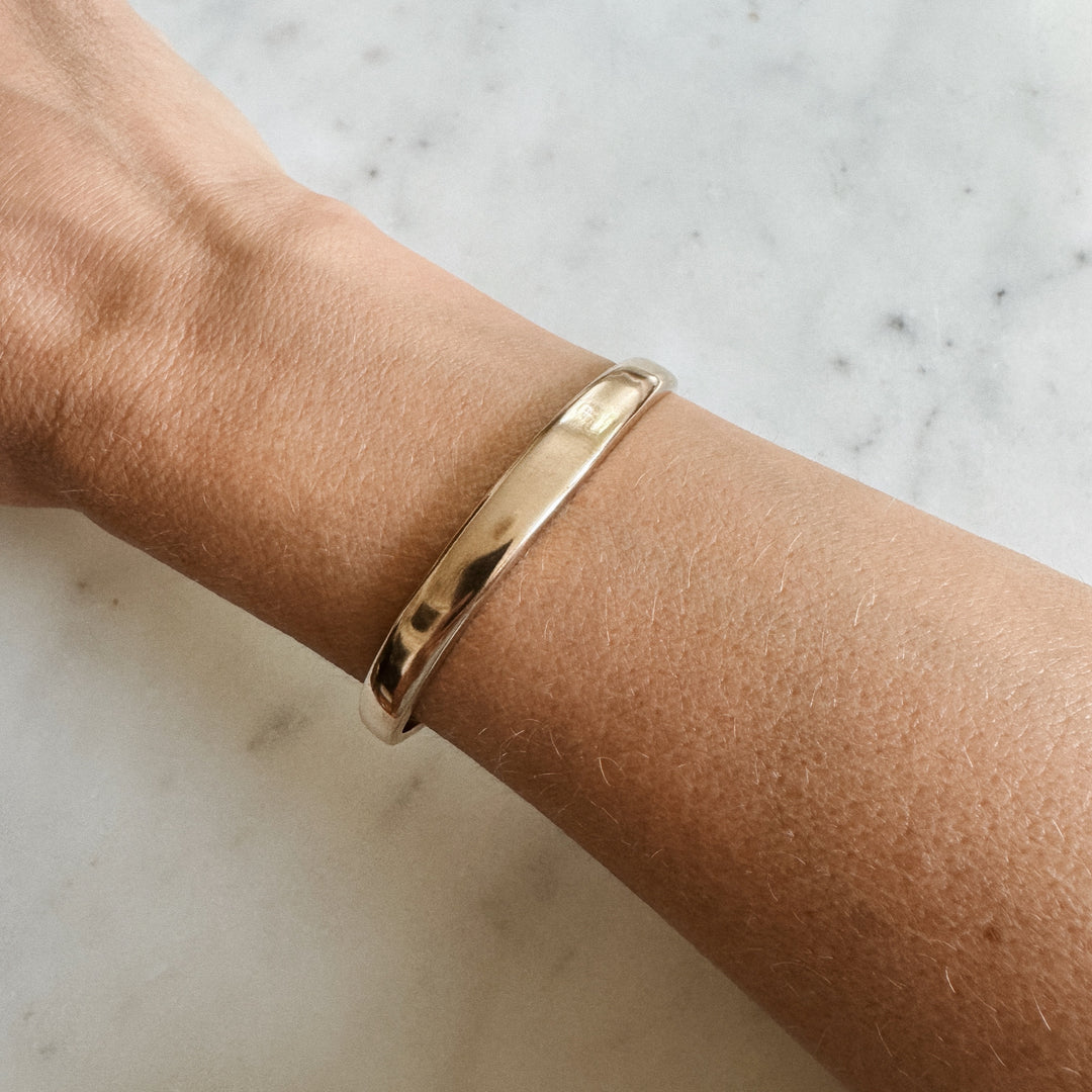 Person Wears the MIMOSA Handcrafted Thin Dome Bracelet in Bronze