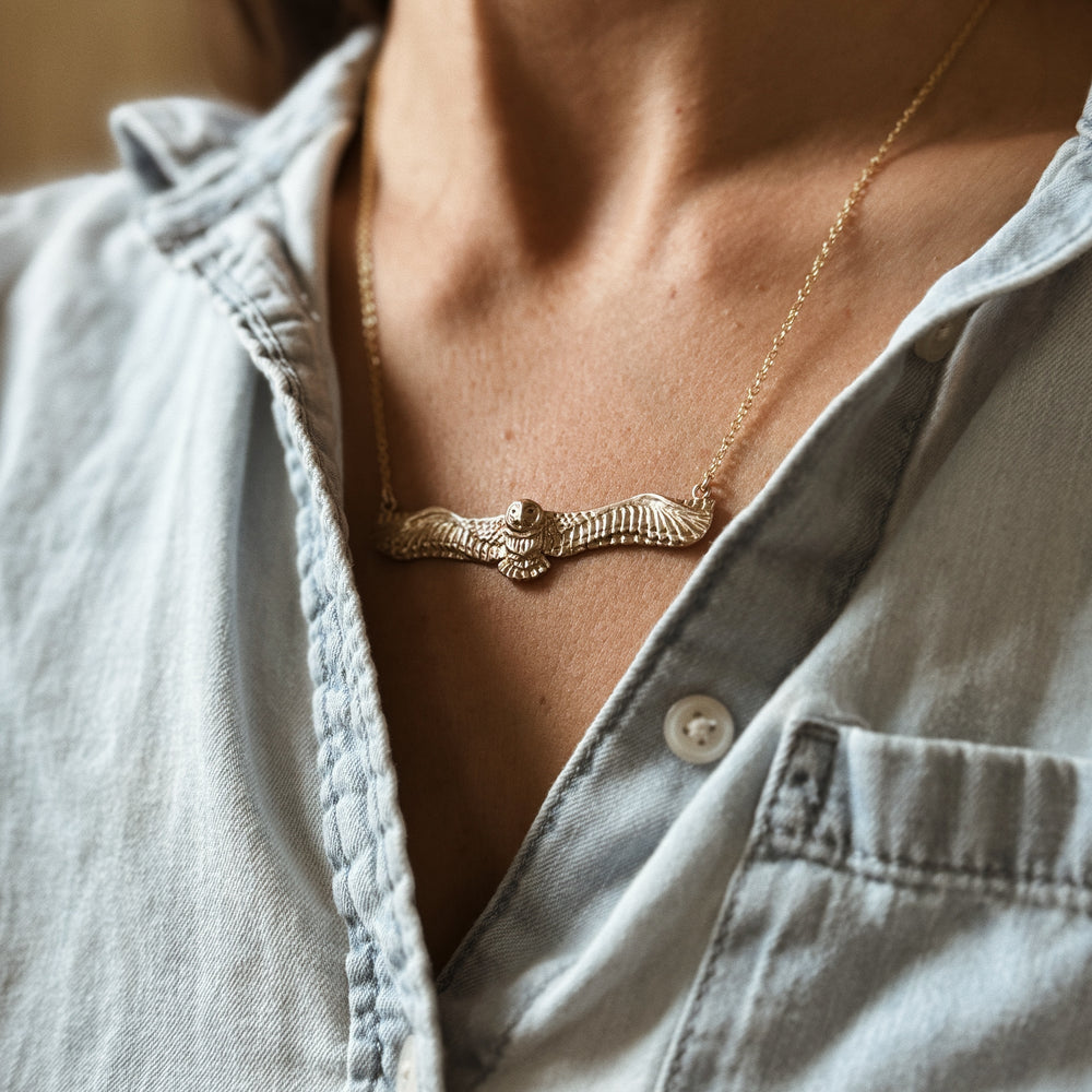 Woman Wears the MIMOSA Handcrafted Owl Necklace in Bronze