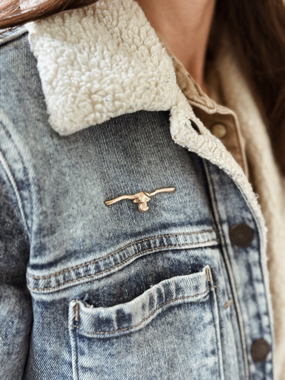 Person Wears the MIMOSA Handcrafted Longhorn Pin in Bronze