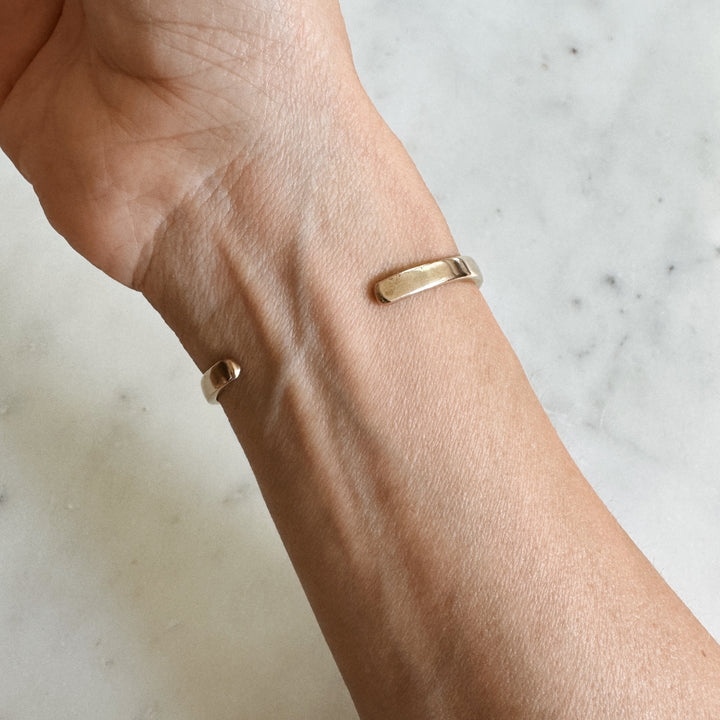 Person Wears the MIMOSA Handcrafted Thin Dome Bracelet in Bronze