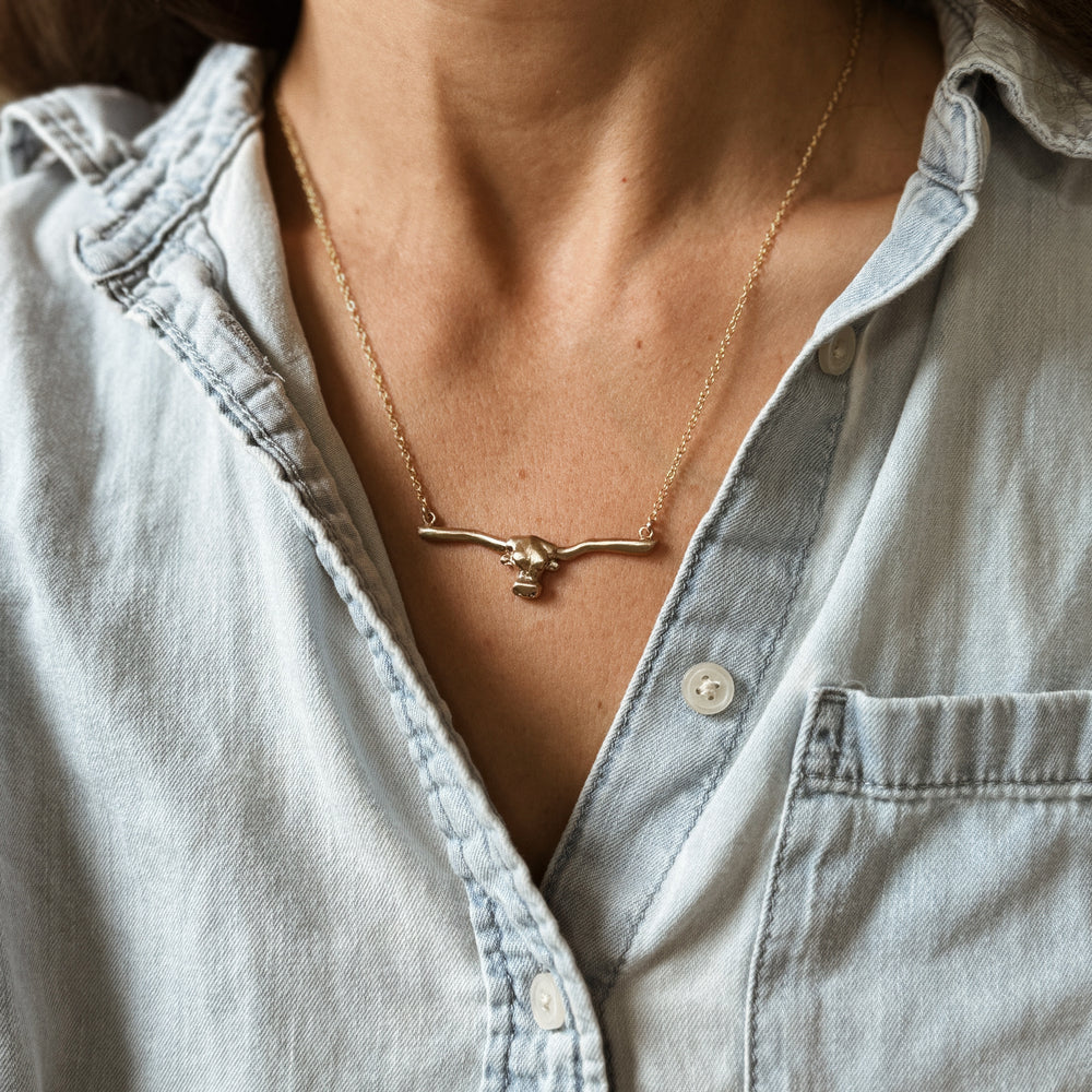 Person Wears the MIMOSA Handcrafted Longhorn Bar Necklace in Bronze