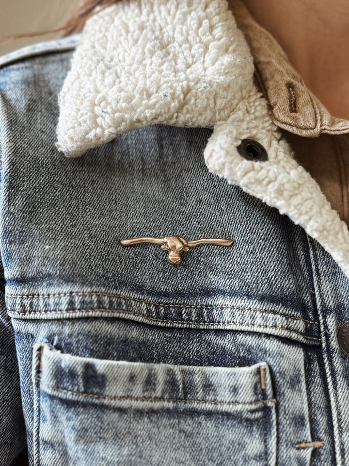 Person Wears the MIMOSA Handcrafted Longhorn Pin in Bronze