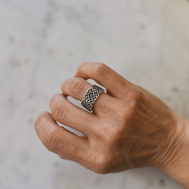 Person wears a handmade granny square ring in sterling silver by MIMOSA Handcrafted