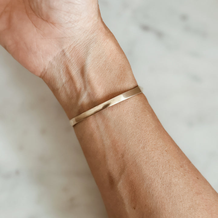 Woman Wears the MIMOSA Handcrafted Horned Toad Bracelet in Bronze