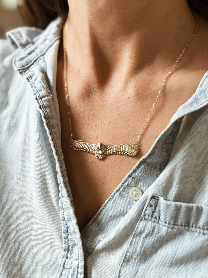 Woman Wears the MIMOSA Handcrafted Owl Necklace in Bronze