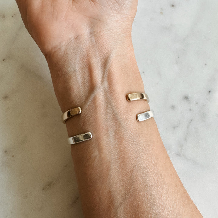 Person Wears the MIMOSA Handcrafted Thin Dome Bracelets in Sterling Silver and Bronze