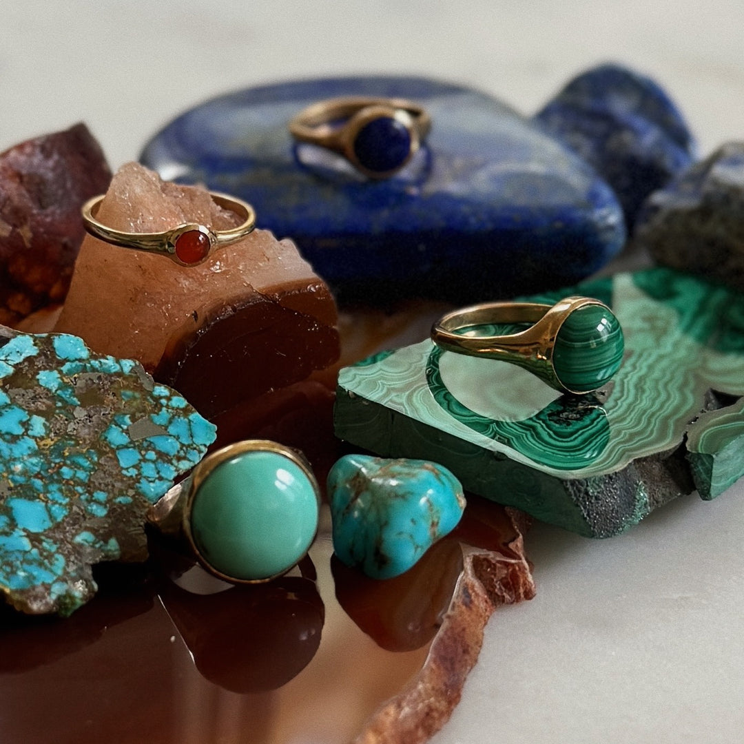 Jewelry with Gemstones on a Stone Surface. Includes Turquoise, Malachite, Lapis, and Carnelian.