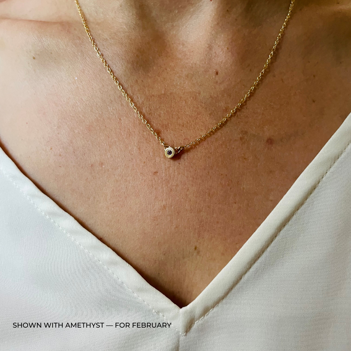 Handmade Bronze Birthstone Necklace with Amethyst on Person Wearing a White Top