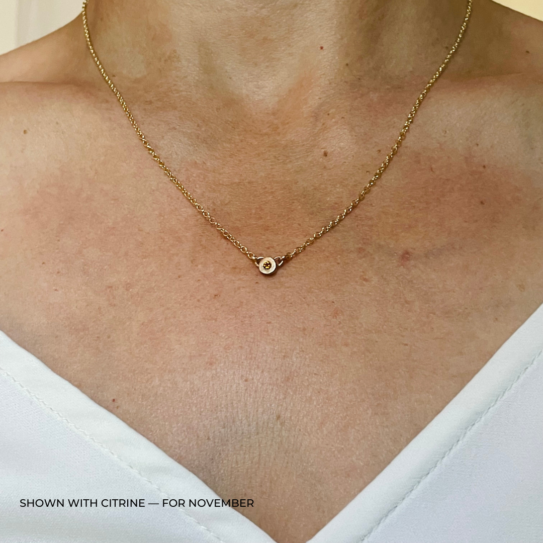 Handmade Bronze Birthstone Necklace with Citrine on Person Wearing a White Top