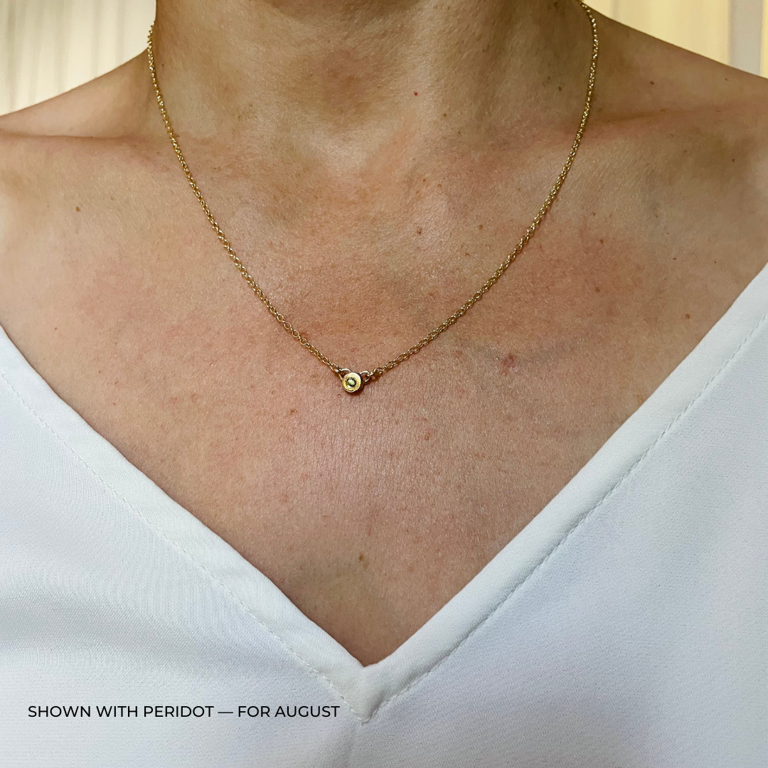 Handmade Bronze Birthstone Necklace with Peridot on Person Wearing a White Top