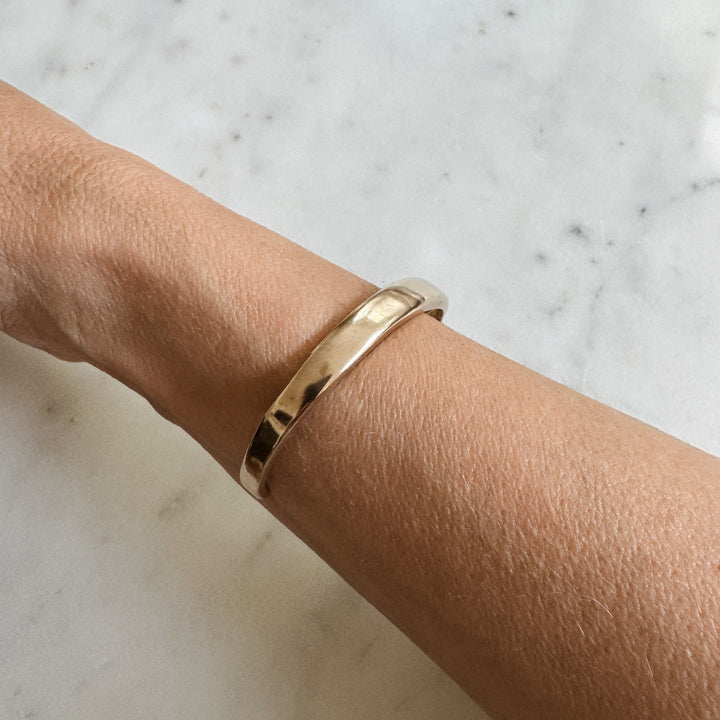 Person Wears the MIMOSA Handcrafted Thin Dome Bracelet in Bronze