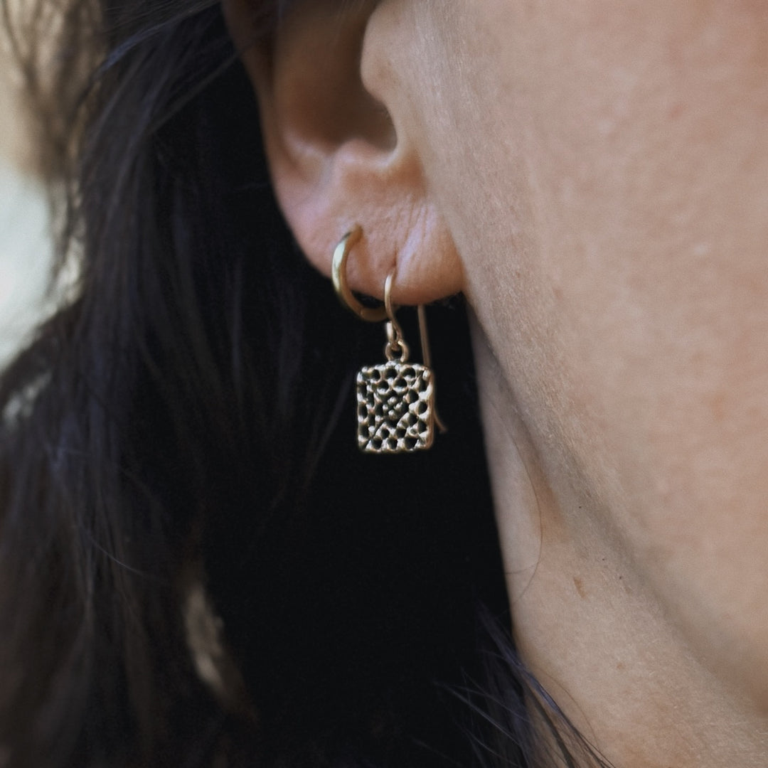 Person wears handmade granny square earrings in bronze by MIMOSA Handcrafted