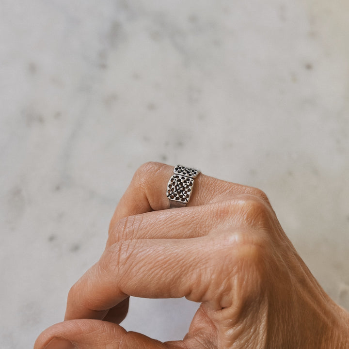 Person wears a handmade granny square ring in sterling silver by MIMOSA Handcrafted