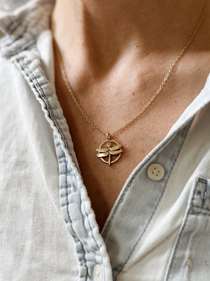 Person Wears MIMOSA Handcrafted's Dragonfly Pendant in Bronze