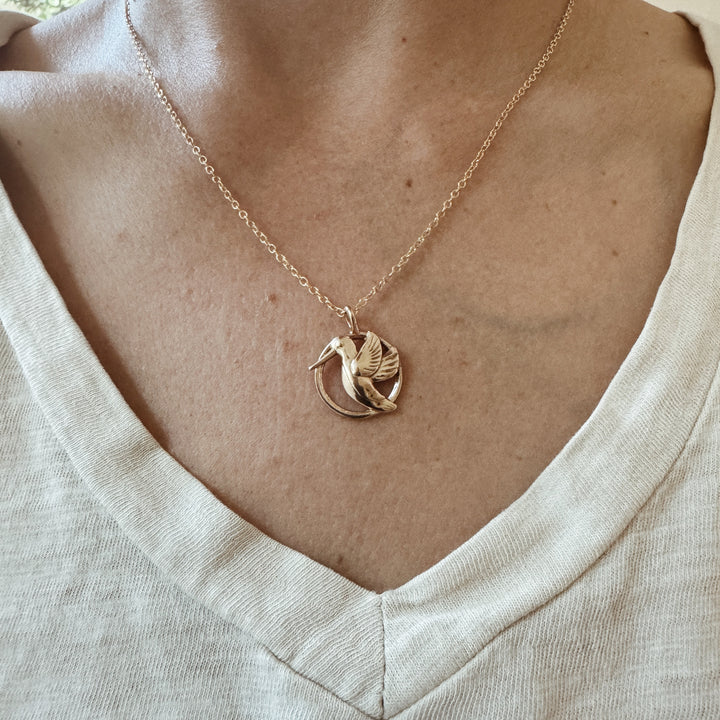 Woman Wears the MIMOSA Handcrafted Hummingbird Pendant in Bronze