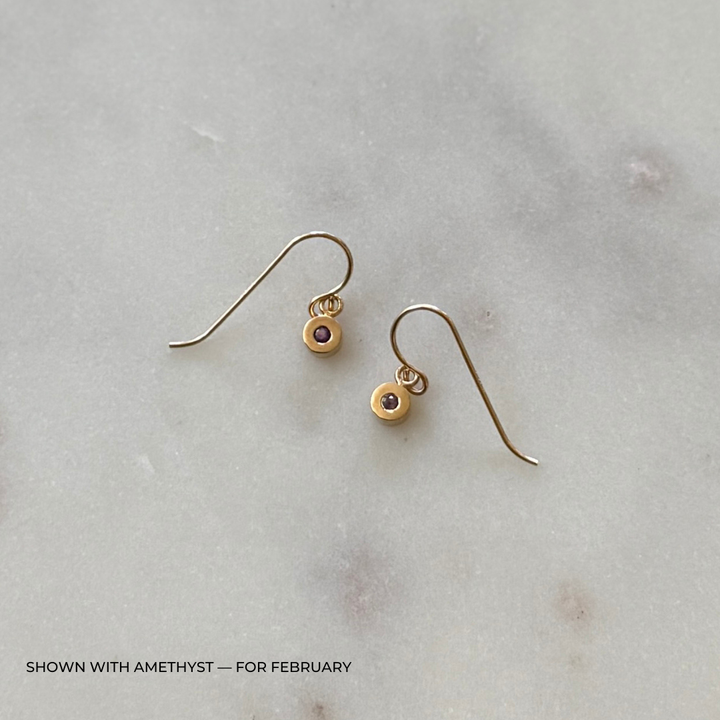 Bronze grace earrings with amethyst gemstones on a light gray surface