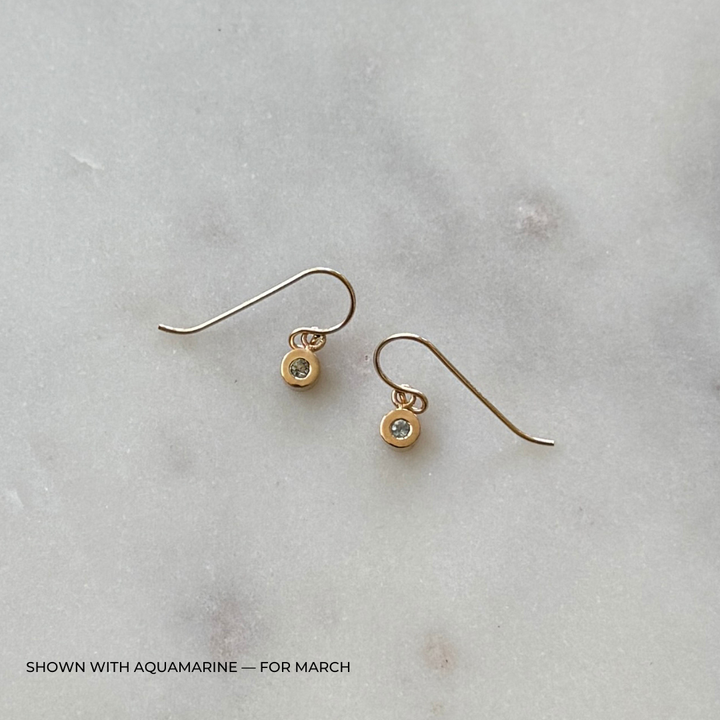 Bronze grace earrings with aquamarine gemstones on a light gray surface