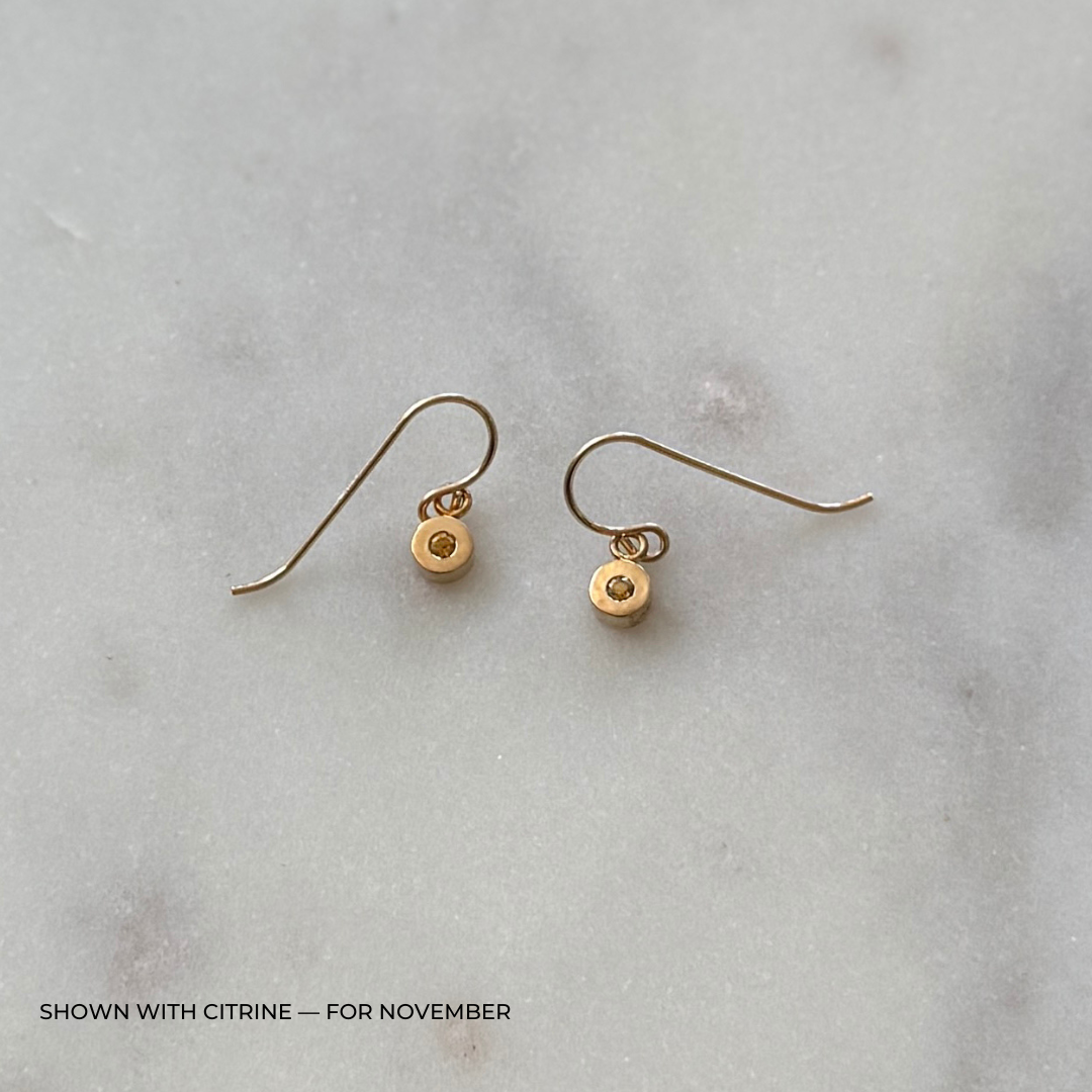 Bronze grace earrings with citrine gemstones on a light gray surface