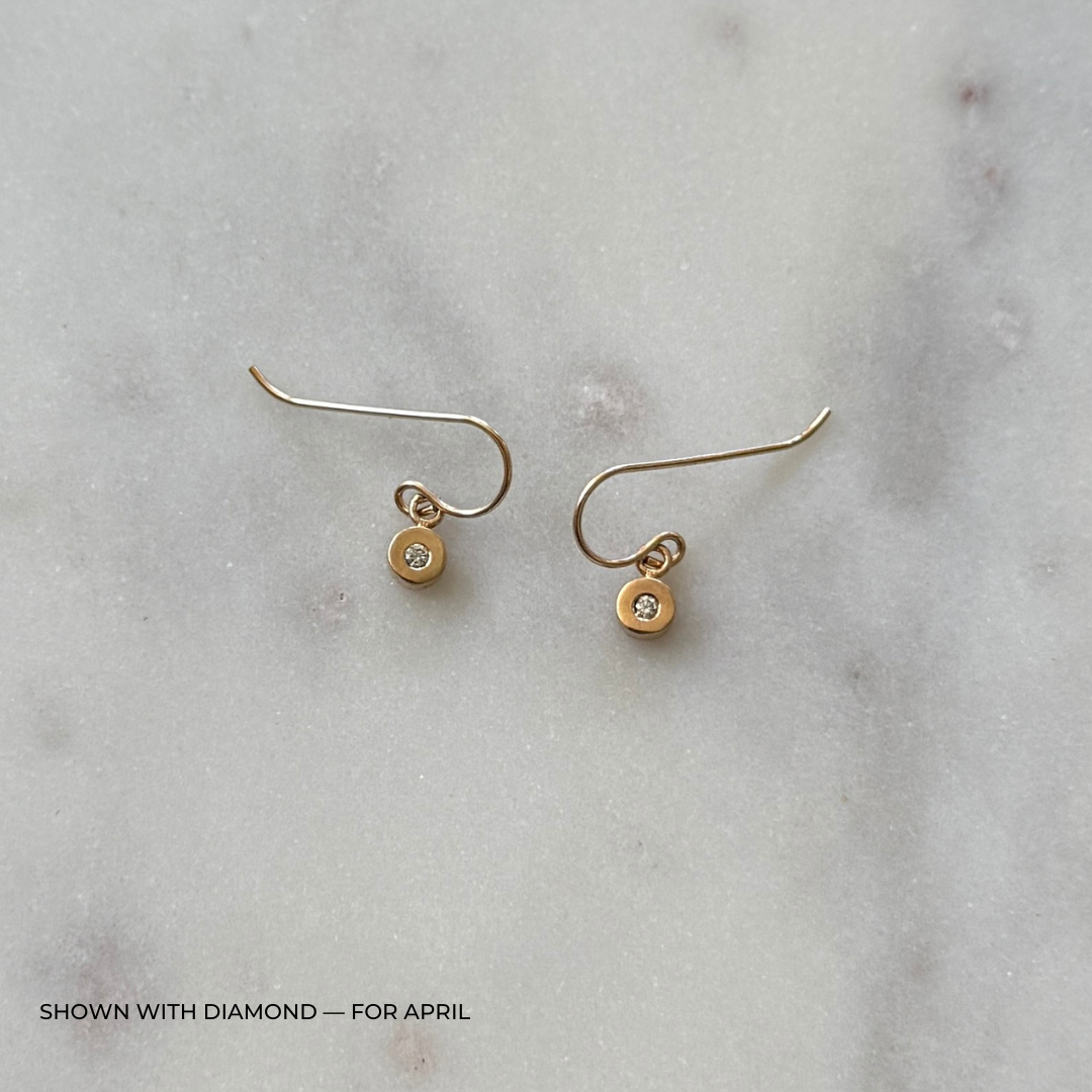 Bronze grace earrings with diamonds on a light gray surface