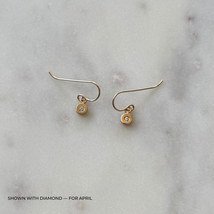 Bronze grace earrings with diamonds on a light gray surface