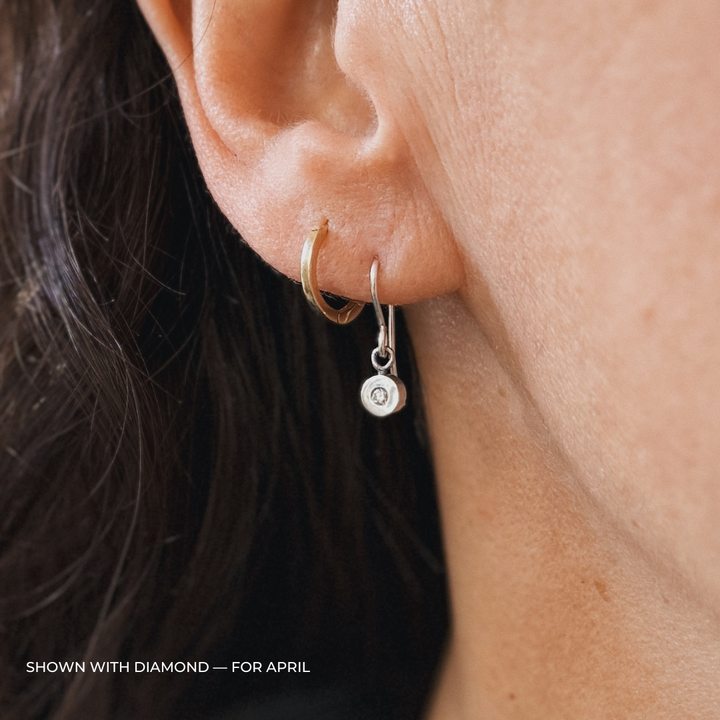Close up of a person wearing silver diamond earrings | MIMOSA Handcrafted