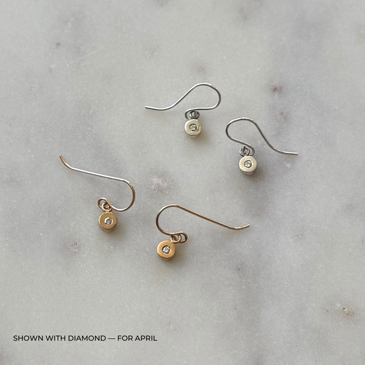 Pair of grace diamond earrings on a light gray background