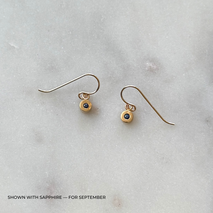 Bronze grace earrings with sapphire gemstones on a light gray surface